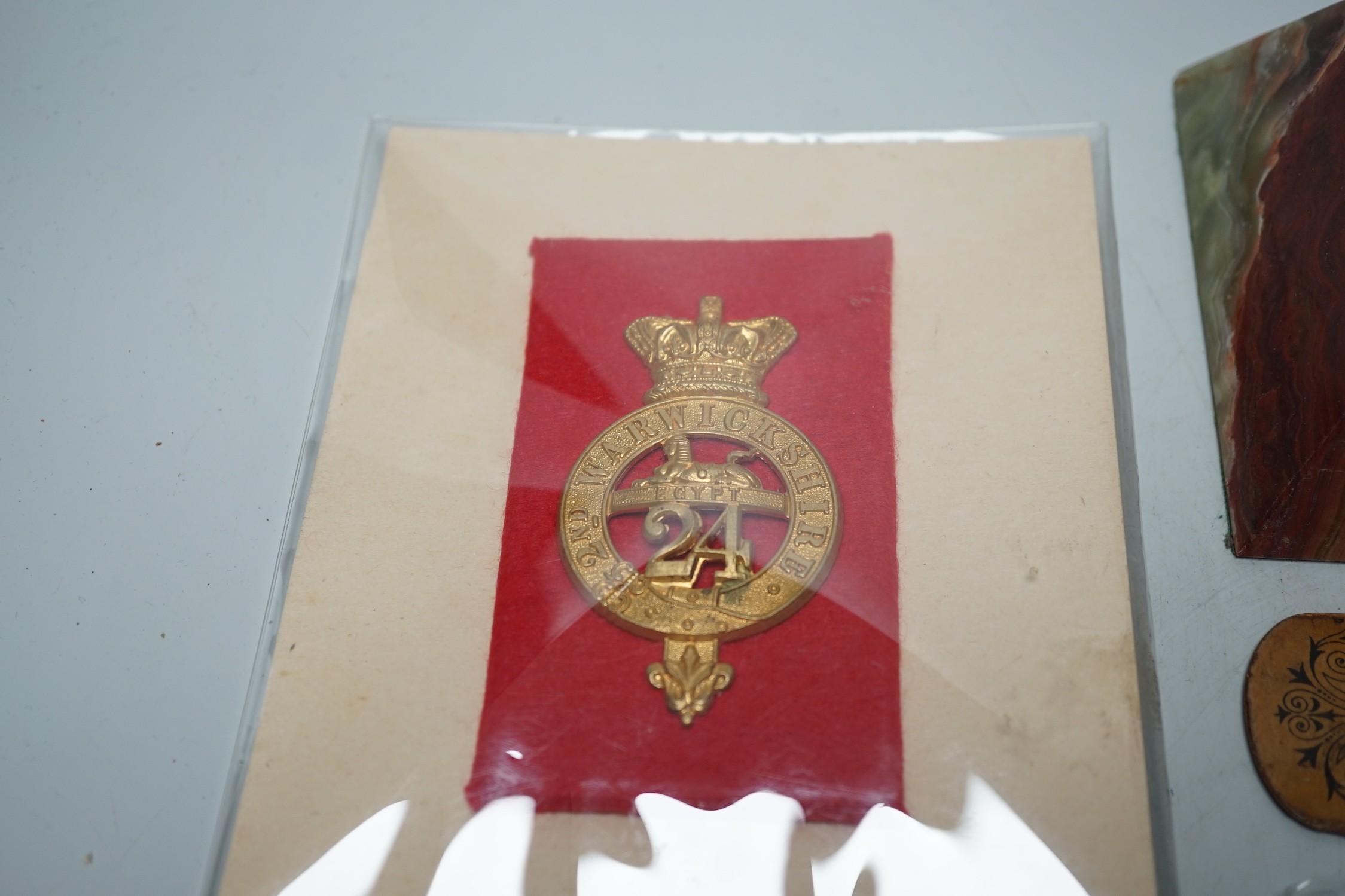 A collection of collectibles: a mother of pearl carves fish, a Mauchlin postal ruler, an enamel box and trays, coinage and various military badges etc